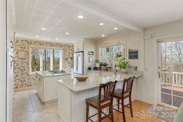 kitchen with a peninsula, stainless steel appliances, and a wealth of natural light