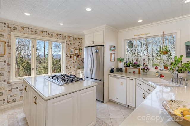 kitchen featuring stainless steel appliances, a sink, light countertops, and white cabinetry