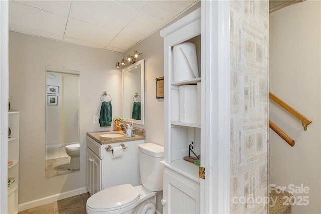 bathroom featuring vanity, toilet, and baseboards