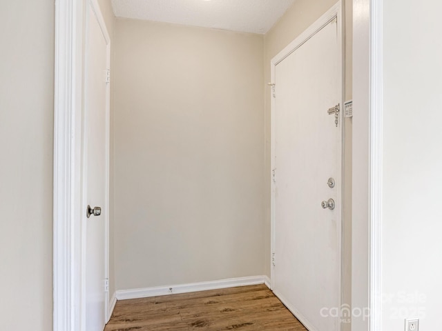 interior space featuring baseboards and wood finished floors