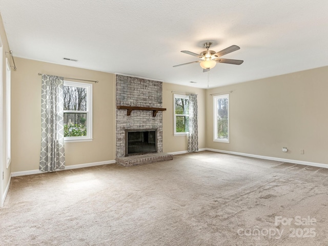 unfurnished living room featuring a ceiling fan, a brick fireplace, carpet flooring, and visible vents