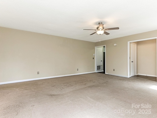 empty room with ceiling fan, a textured ceiling, carpet, and baseboards