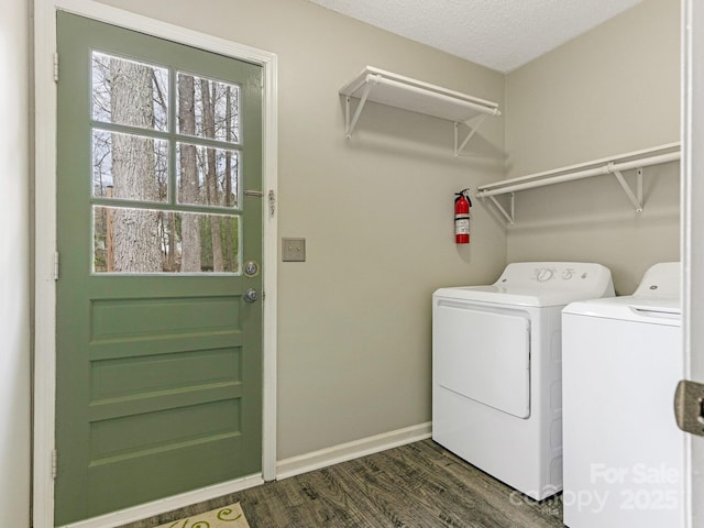 laundry area featuring a textured ceiling, laundry area, baseboards, washer and clothes dryer, and dark wood finished floors