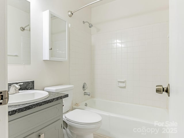 bathroom featuring washtub / shower combination, toilet, and vanity