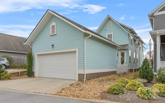 view of side of home featuring an attached garage and driveway