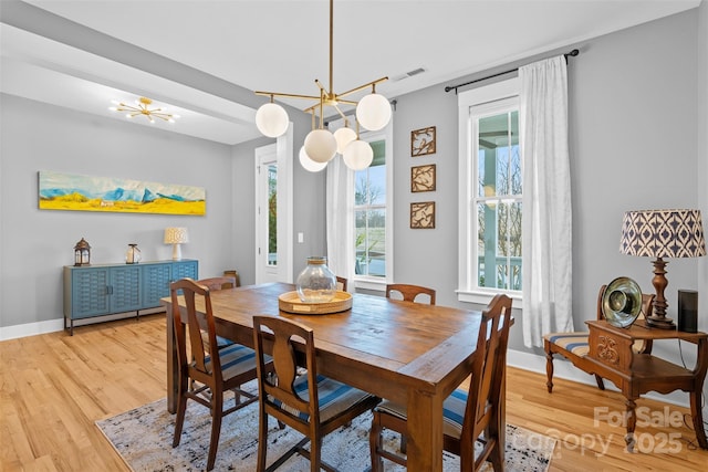 dining room featuring a chandelier, baseboards, and wood finished floors