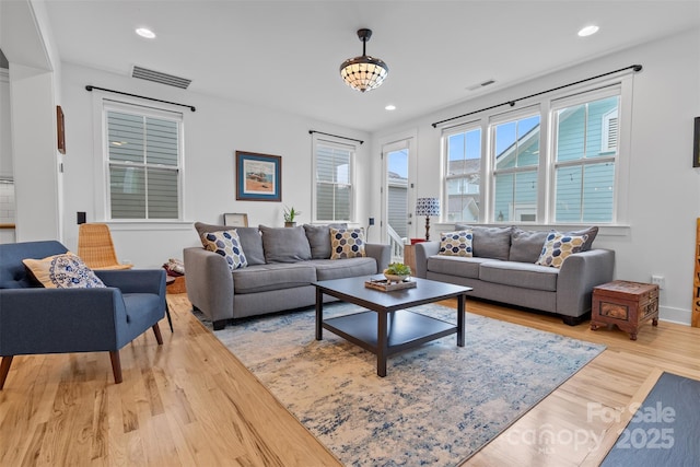 living area with recessed lighting, wood finished floors, and visible vents