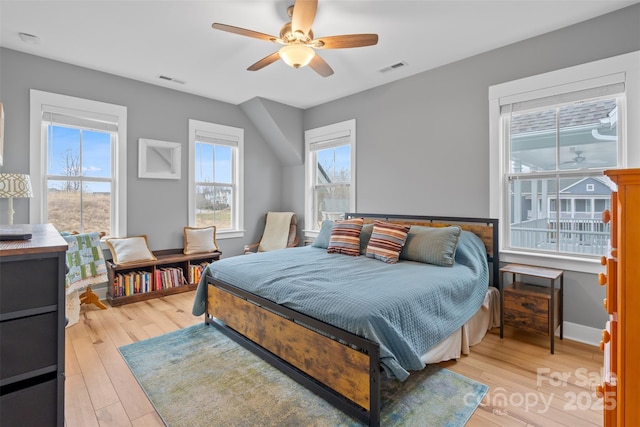 bedroom featuring a ceiling fan, visible vents, light wood-type flooring, and baseboards