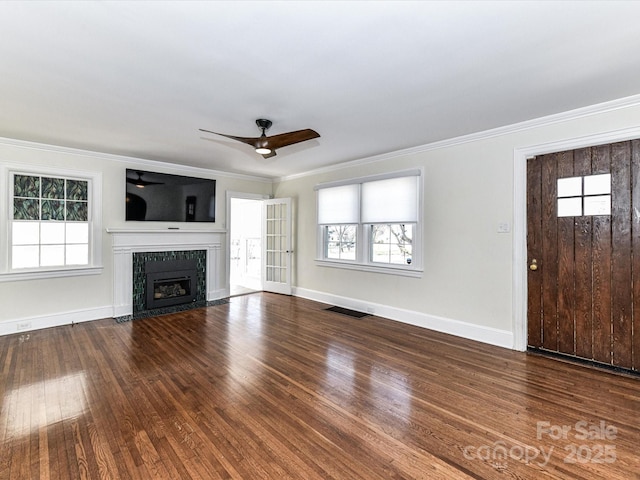 unfurnished living room with visible vents, crown molding, a fireplace with flush hearth, and wood finished floors