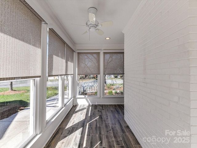 unfurnished sunroom featuring a ceiling fan