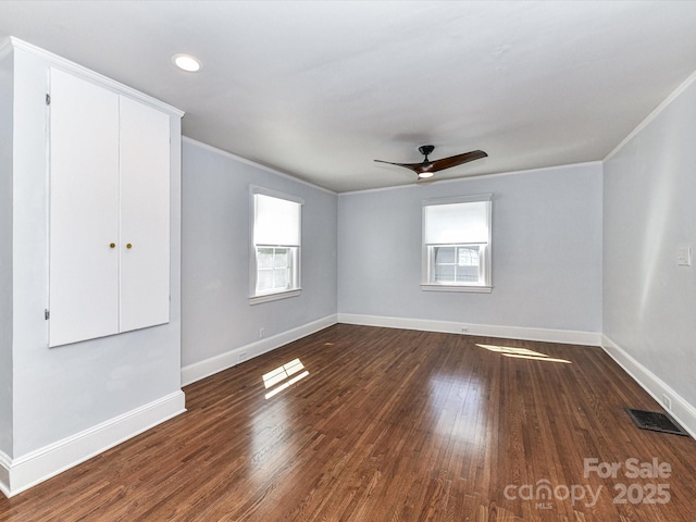 unfurnished room featuring visible vents, plenty of natural light, and wood finished floors