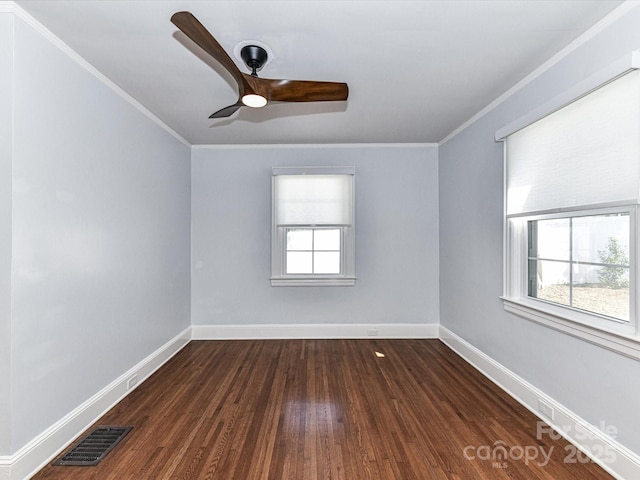 spare room featuring visible vents, dark wood finished floors, and crown molding