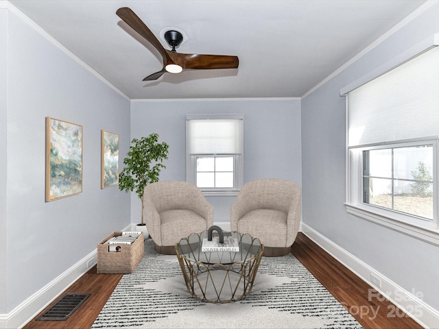 sitting room featuring wood finished floors, visible vents, and ornamental molding