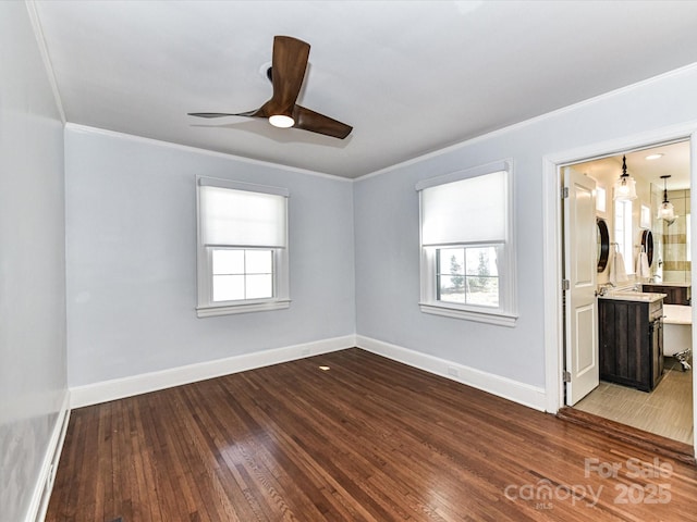 spare room with plenty of natural light, a ceiling fan, dark wood-style flooring, and baseboards