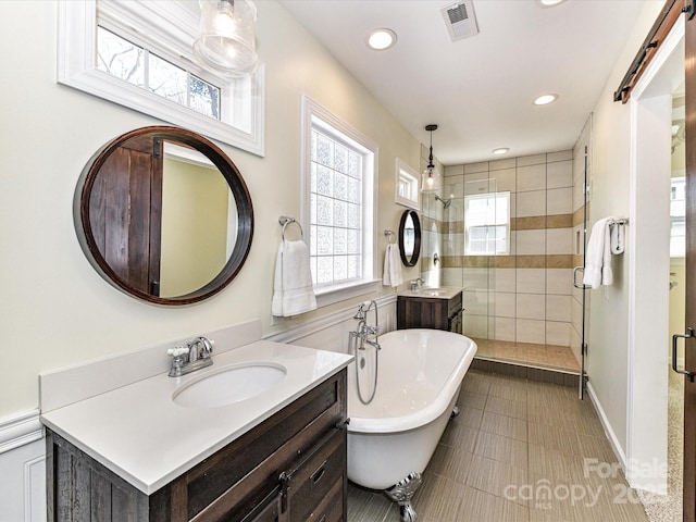 bathroom featuring a soaking tub, visible vents, a stall shower, and vanity