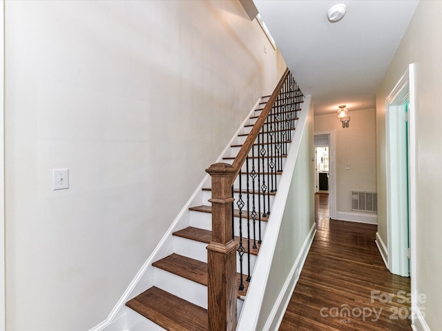 stairs featuring visible vents, baseboards, and wood finished floors