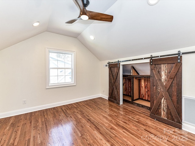 additional living space featuring visible vents, lofted ceiling, wood finished floors, and a ceiling fan