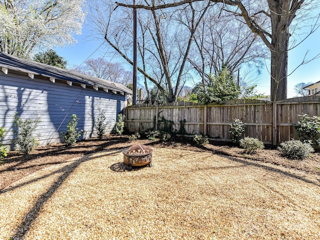 view of yard with fence and an outdoor fire pit