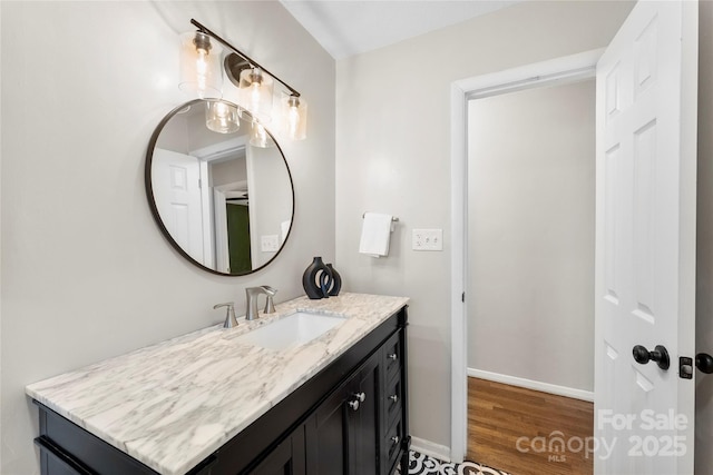 bathroom with vanity, baseboards, and wood finished floors