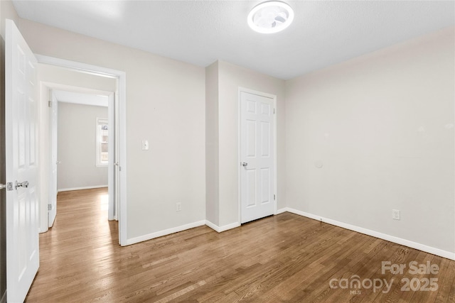 unfurnished room featuring wood finished floors and baseboards