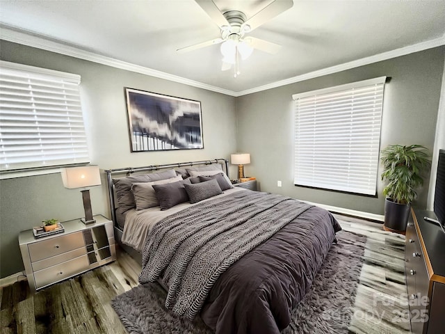 bedroom featuring ornamental molding, ceiling fan, baseboards, and wood finished floors