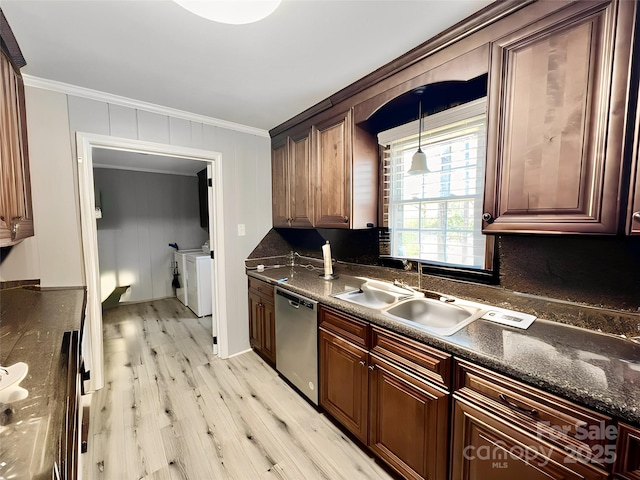 kitchen with a sink, crown molding, washer and clothes dryer, and dishwasher