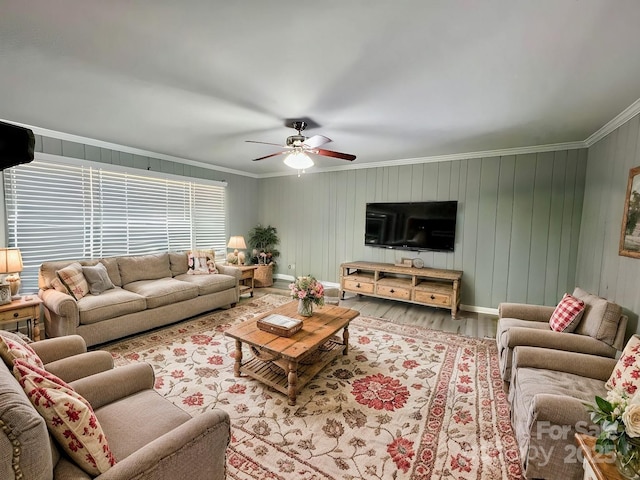 living area with ceiling fan, baseboards, wood finished floors, and crown molding