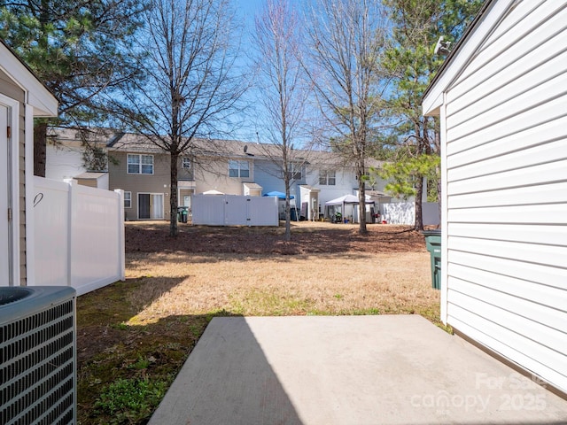 view of yard with central AC unit, a patio, and fence