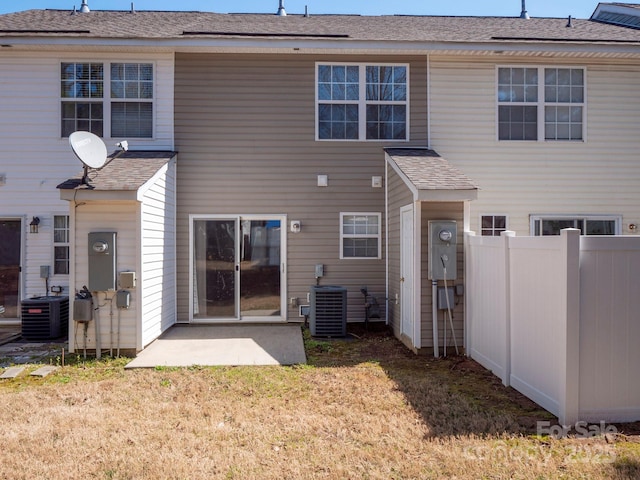 rear view of property with a yard, central air condition unit, a patio, and fence