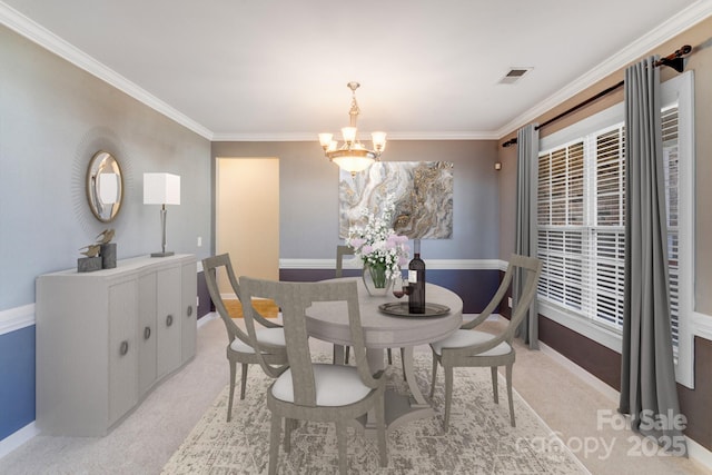 dining area featuring light colored carpet, visible vents, ornamental molding, a chandelier, and baseboards