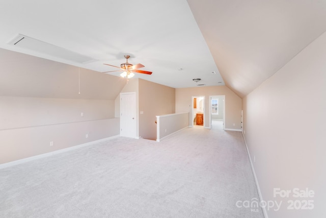 bonus room with light carpet, attic access, baseboards, and lofted ceiling