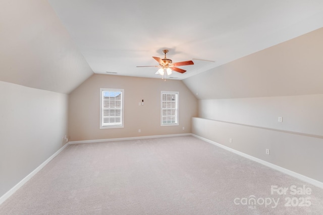 bonus room with light carpet, vaulted ceiling, baseboards, and ceiling fan