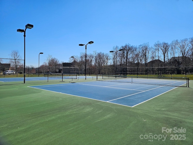 view of tennis court featuring fence