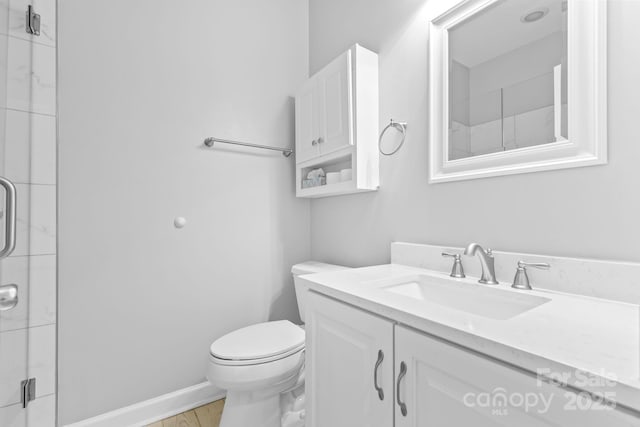 full bath featuring baseboards, toilet, wood finished floors, vanity, and a shower stall