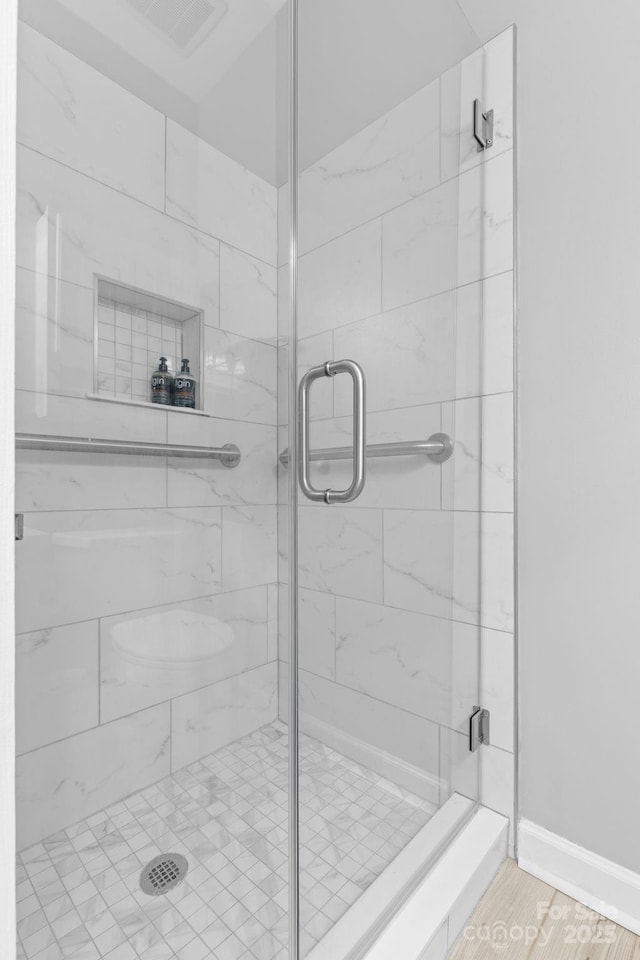 full bath with a shower stall, visible vents, and baseboards