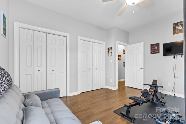 exercise room featuring ceiling fan, baseboards, and wood finished floors