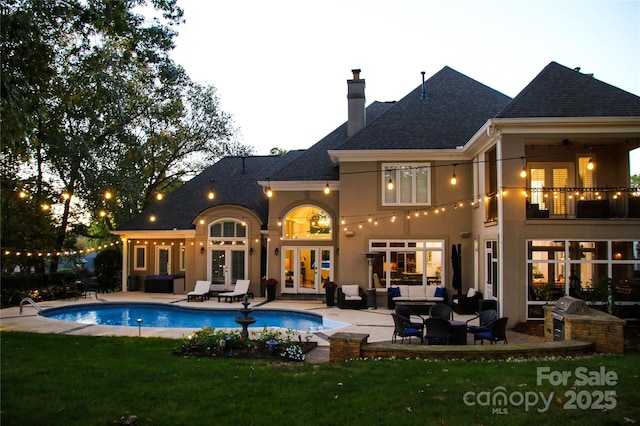 rear view of property with french doors, a patio, a balcony, and an outdoor hangout area