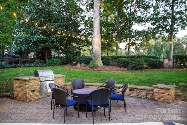 view of patio / terrace featuring exterior kitchen, grilling area, and fence