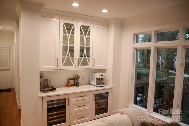 bar with a dry bar, beverage cooler, wood finished floors, and recessed lighting