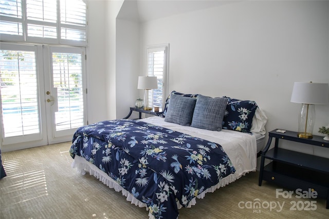 bedroom featuring access to exterior, multiple windows, and french doors