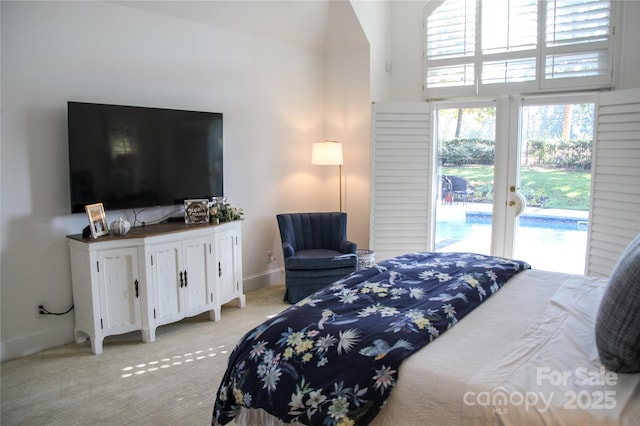 bedroom with light carpet, a high ceiling, baseboards, and access to exterior