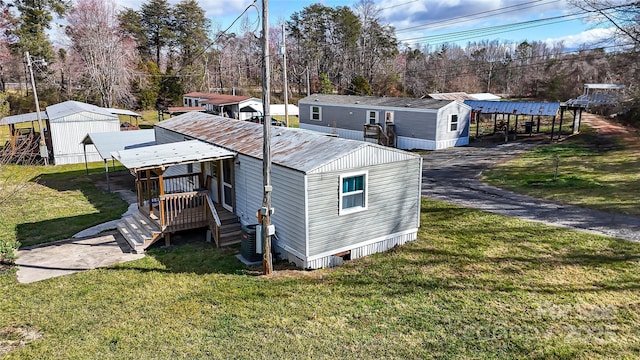 exterior space featuring an outbuilding, a yard, and metal roof