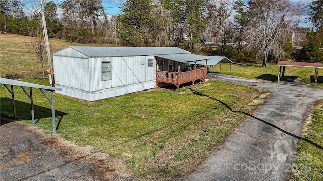 view of front facade with aphalt driveway, a carport, and a front yard