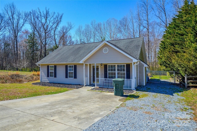 view of front of house with a gate, fence, driveway, a porch, and a shingled roof