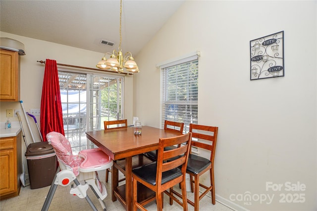 dining area with an inviting chandelier, plenty of natural light, visible vents, and vaulted ceiling