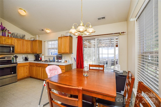 dining room with visible vents, a textured ceiling, an inviting chandelier, light floors, and vaulted ceiling