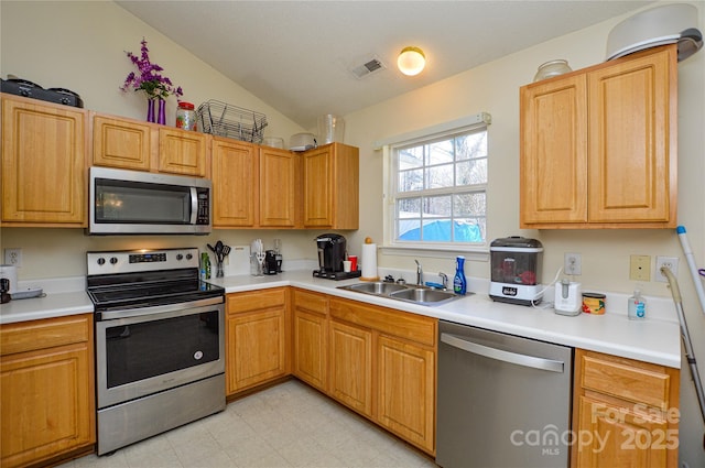 kitchen featuring visible vents, a sink, stainless steel appliances, light countertops, and lofted ceiling