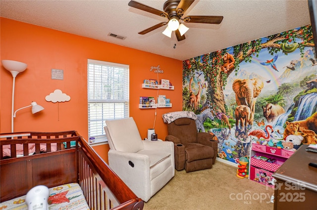 carpeted bedroom featuring visible vents, a textured ceiling, and ceiling fan