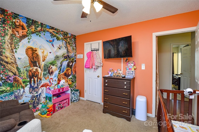 rec room with baseboards, light carpet, a textured ceiling, and a ceiling fan