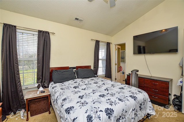 bedroom featuring visible vents, ceiling fan, vaulted ceiling, light carpet, and a textured ceiling